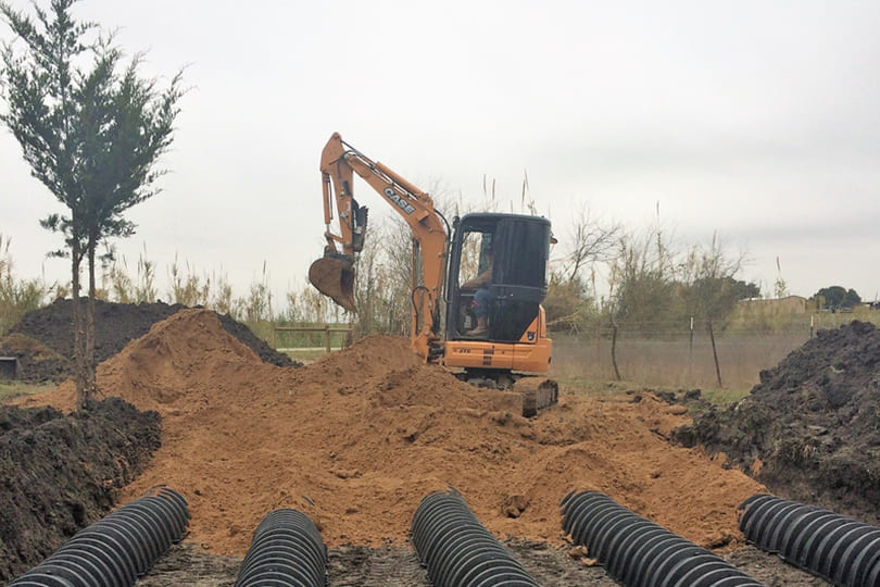 Excavator with in-ground septic system